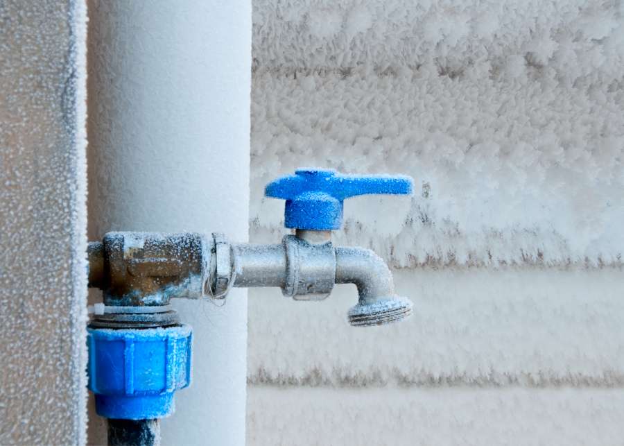 A frozen outdoor faucet (also called hose bib) in winter. Frost covers the faucet.